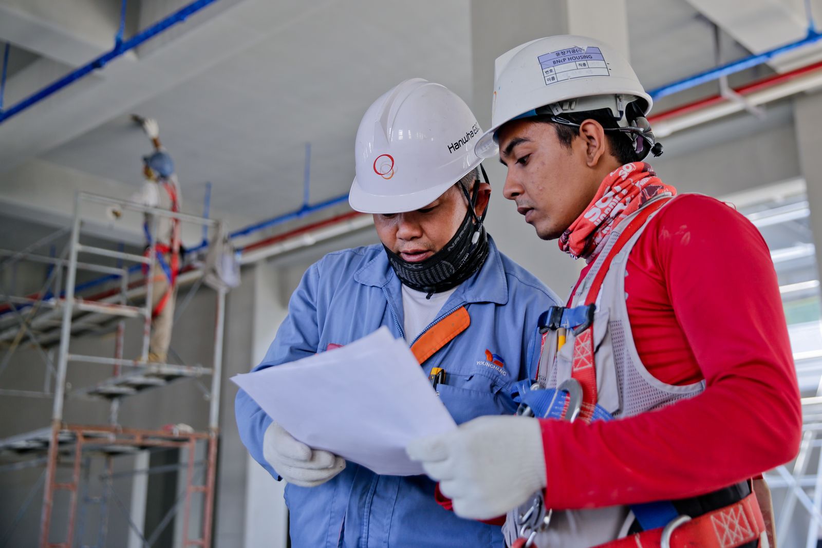 Industrial workers in safety helmets collaborating on site